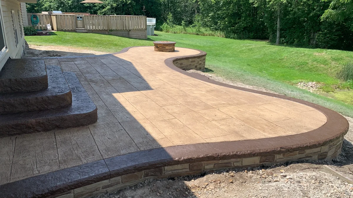 Curved stamped concrete patio with an integrated fire pit